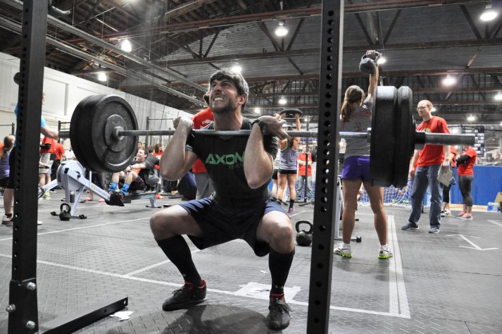 This pictures shows a man in the middle of a front squat.